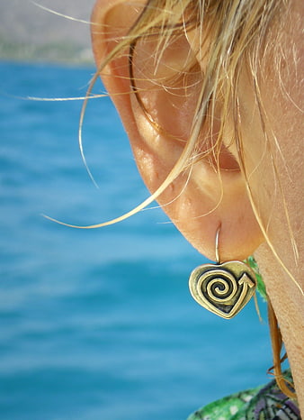 Close-up of woman's ear with heart-shaped spiral earring