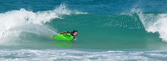 Man bodyboarding on a green wave in the ocean