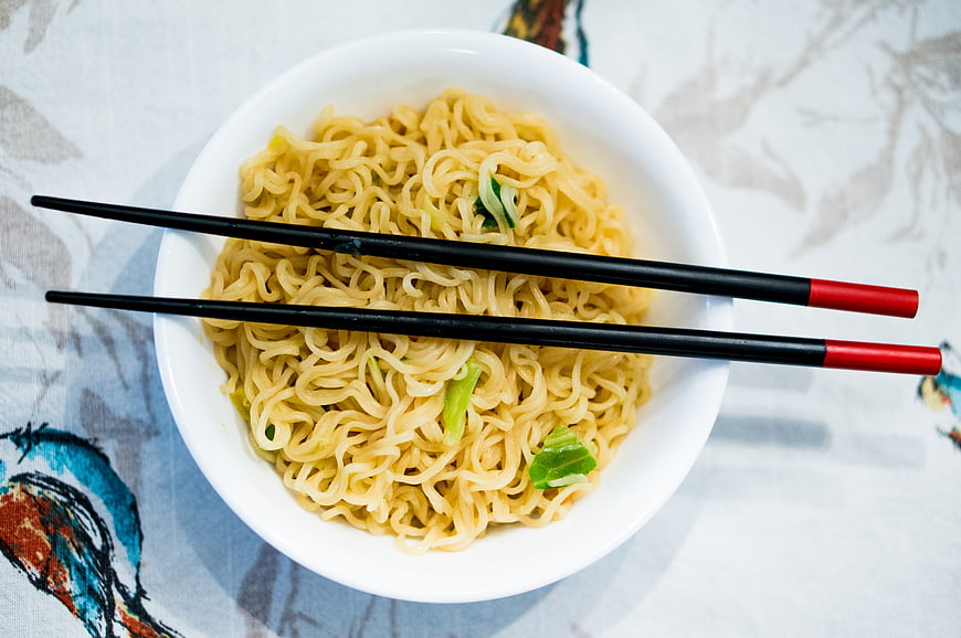 Top View of Instant Noodles with Chopsticks in White Bowl