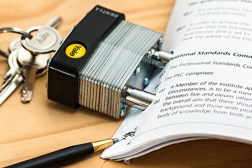 Yale padlock securing legal contract document with pen
