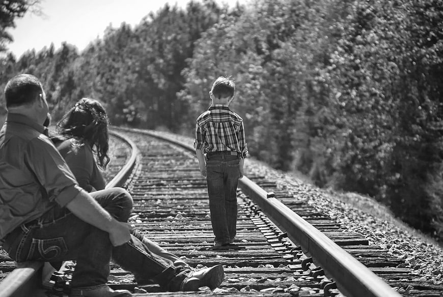 Black and white photo of family on railroad tracks