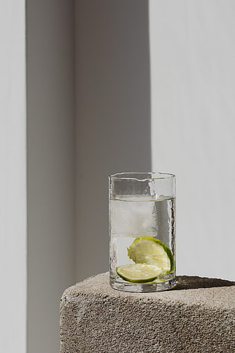 Refreshing Glass of Water with Lime Slices on Concrete