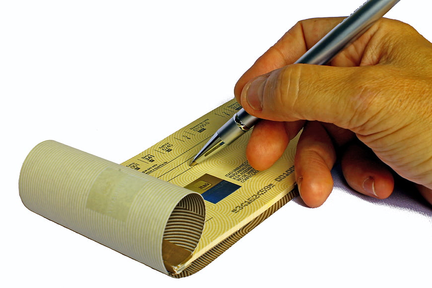 Hand Writing on a Yellow Checkbook with Pen
