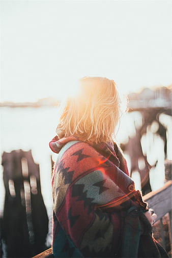 Woman in Patterned Poncho Backlit by Sunset Sun Flare