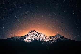 Snowy Mountain Peak Under Starry Night Sky with Meteor Trails