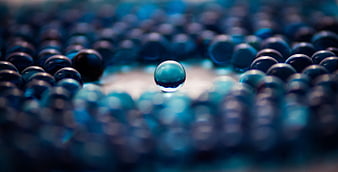 Blue glass marble standing alone in a crowd of spheres