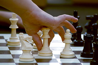 Hand Moving Chess Piece on Board
