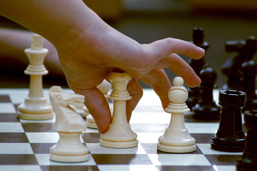 Hand Moving Chess Piece on Board