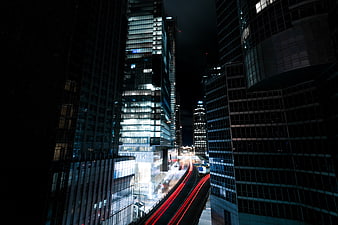 Night cityscape with long exposure light trails between skyscrapers