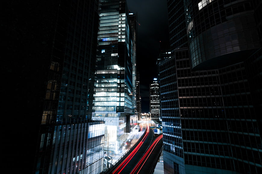 Night cityscape with long exposure light trails between skyscrapers