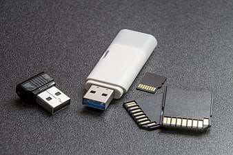 White USB Flash Drive and Memory Cards on Dark Textured Surface
