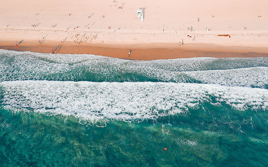 Aerial View of Turquoise Ocean Waves Crashing on Sandy Beach