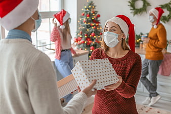 Family Exchanging Christmas Gifts While Wearing Face Masks