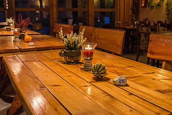 Rustic wooden restaurant table with autumn decorations and candle