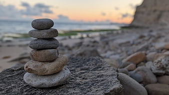 Zen stone stack on a rocky beach at sunset