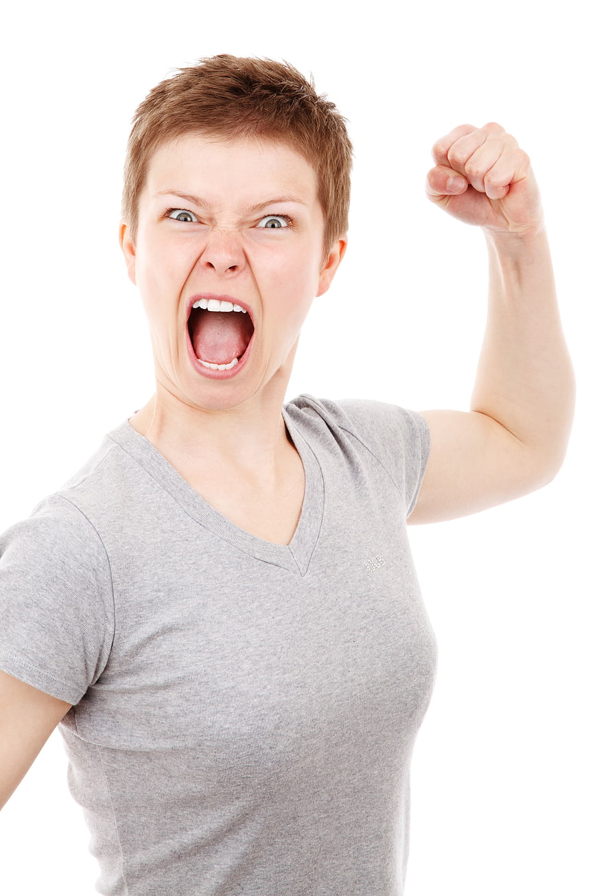 Angry woman screaming with raised fist on white background