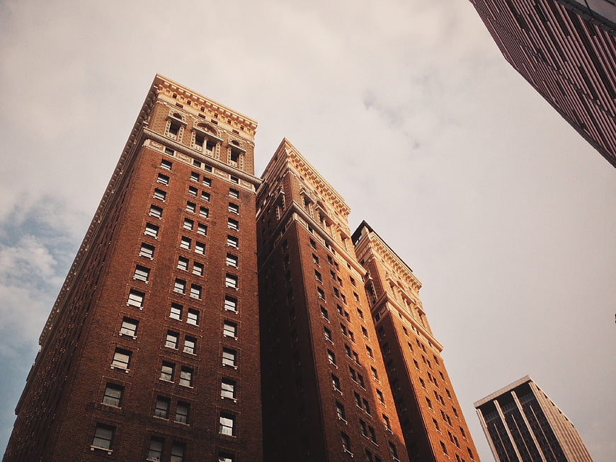 Low angle view of historic brick apartment buildings against cloudy sky