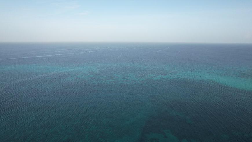 Aerial View of Calm Blue Ocean with Coral Reef Patterns