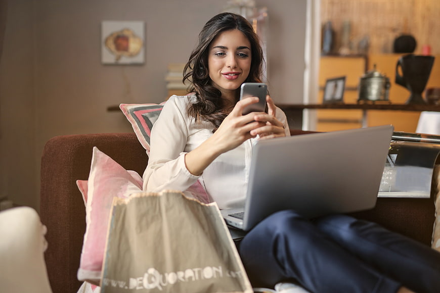 Woman online shopping on laptop and smartphone at home