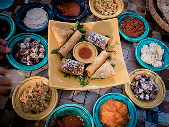 Overhead view of Moroccan appetizers and dips on a tiled table