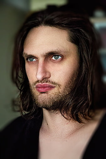 Intense portrait of man with long hair and piercing blue eyes