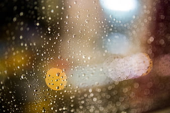 Raindrops on Glass with Bokeh Lights Background