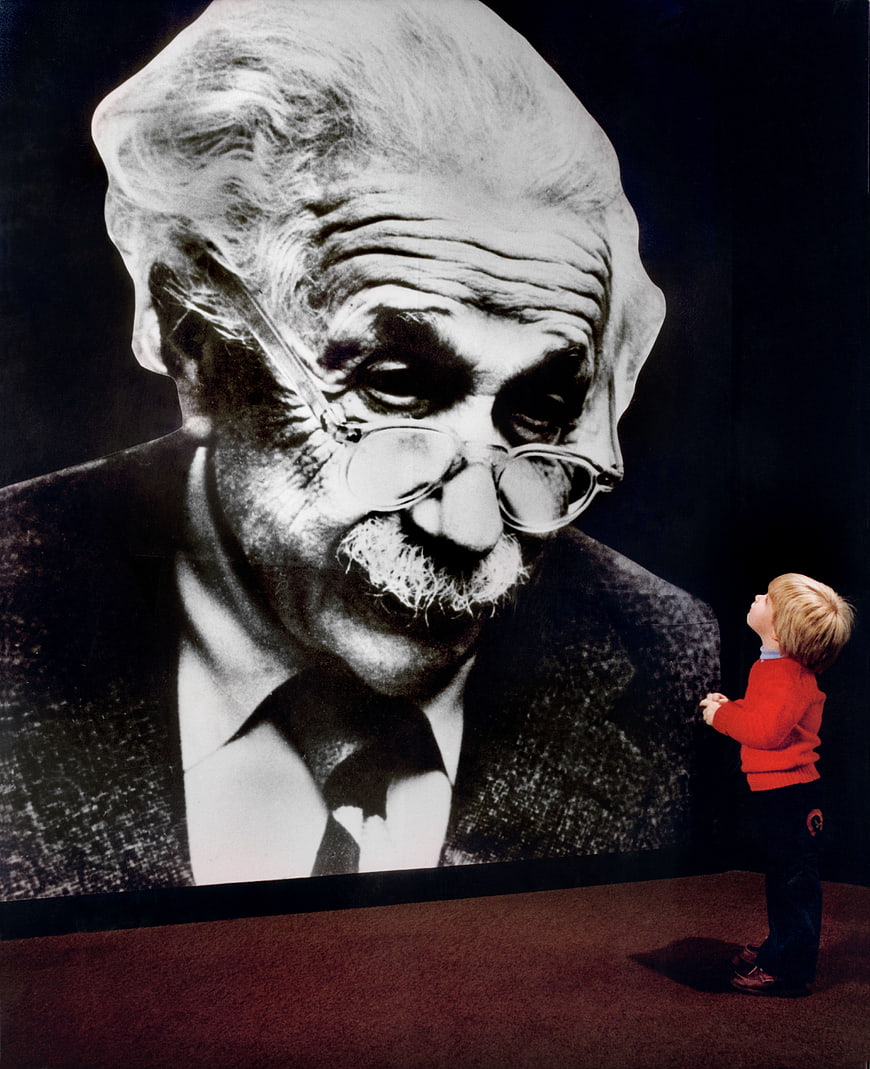 Child looking up at giant portrait of Albert Einstein