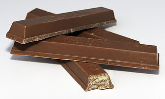 Stacked Milk Chocolate Bars With Nuts On White Background