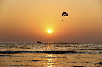 Parasailing Silhouette Over Ocean at Golden Sunset