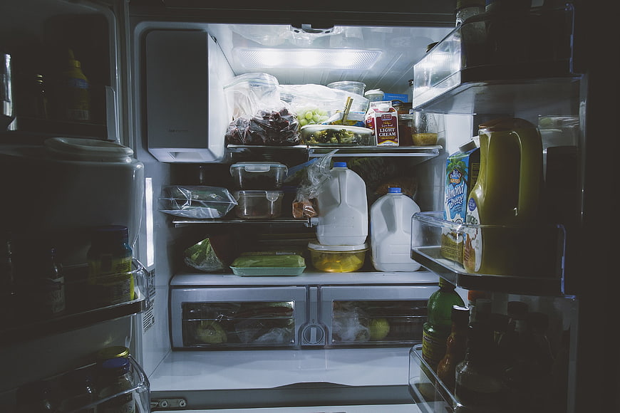 Inside a well-stocked refrigerator with groceries and milk