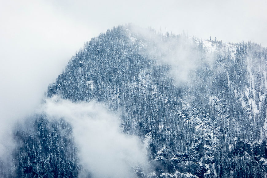 Snowy Mountain Peak Shrouded in Thick Winter Fog