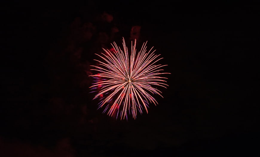Red Fireworks Bursting Against Dark Night Sky