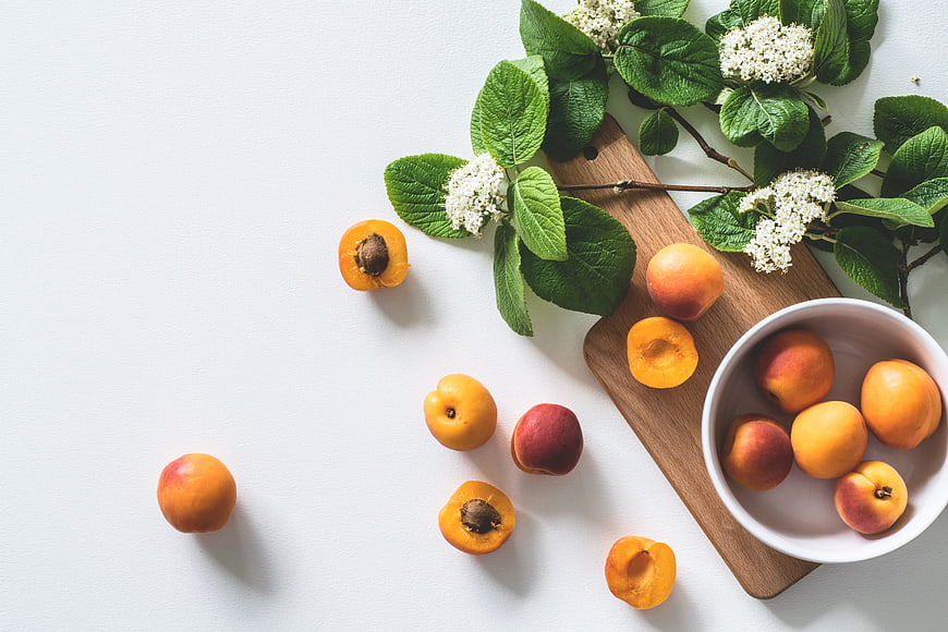 Fresh Apricots and Elderflower Branches on White Background