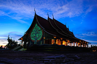 Illuminated Thai Temple At Dusk With Glowing Tree Design
