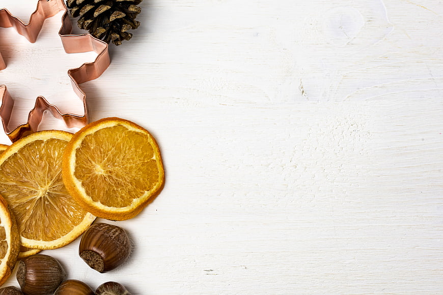Christmas baking background with dried orange slices, chestnuts, and copper cookie cutters