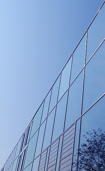 Modern Glass Office Building Facade Against Blue Sky