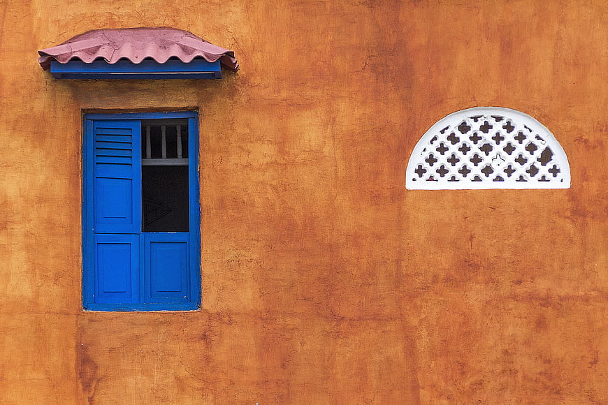Blue Window and White Lattice on Orange Wall