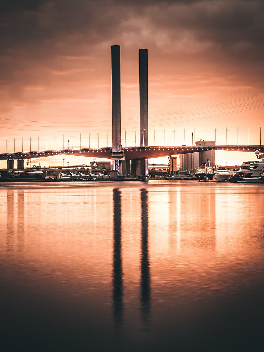 Sunset Reflection of Suspension Bridge Over Calm Water