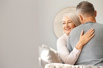 Happy Senior Couple Embracing on Sofa with Copy Space