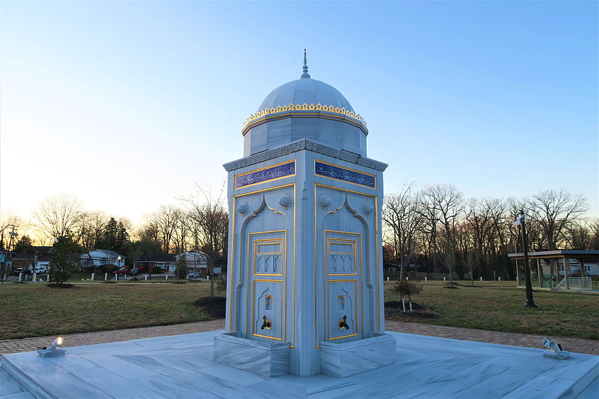 White marble fountain with gold accents in a park
