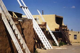 Adobe Pueblo Architecture with Wooden Ladders in Desert