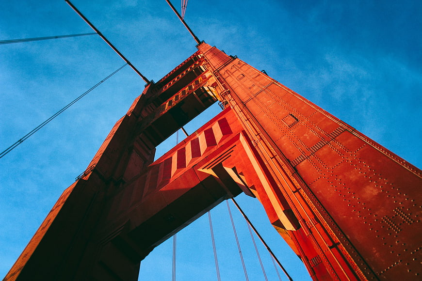 Low angle view of Golden Gate Bridge tower against blue sky