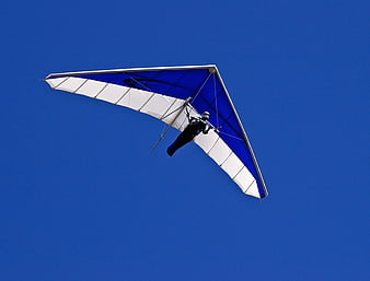 Hang Glider Pilot Soaring Against Clear Blue Sky