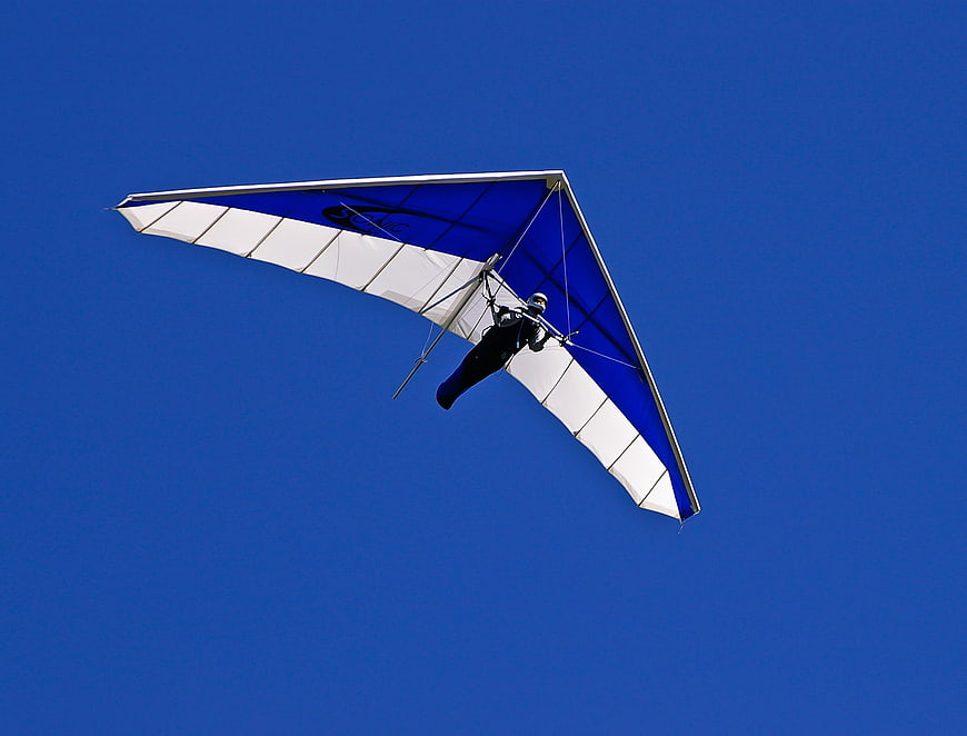 Hang Glider Pilot Soaring Against Clear Blue Sky
