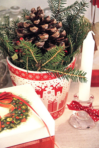 Christmas centerpiece with pine cone, candle, and gift box