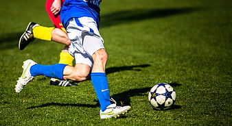 Soccer players dueling for the ball on a grass field