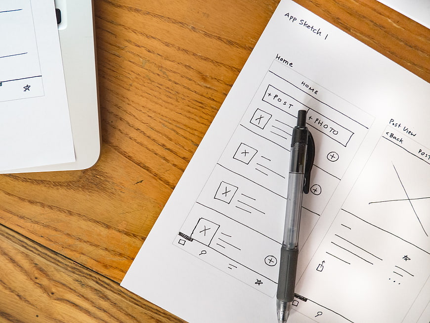 Hand-drawn mobile app wireframe sketch on paper