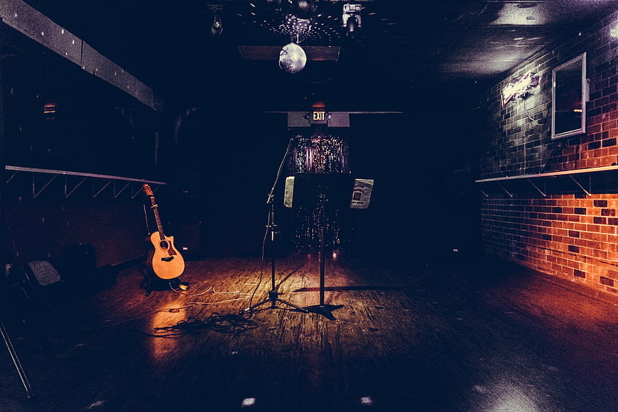 Empty Dive Bar Stage with Guitar and Microphone