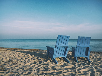 Two Blue Adirondack Chairs on Sandy Beach Facing Ocean