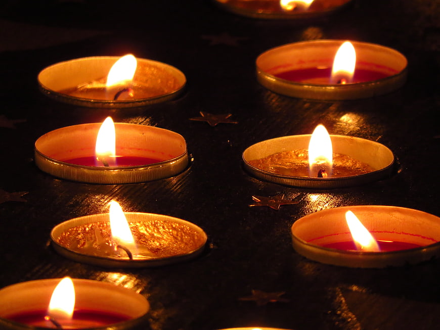 Tea light candles with star decorations on dark wood